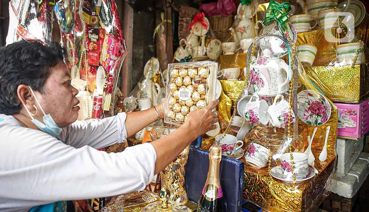 Pedagang mengemas parsel Natal di Pasar Barito, Jakarta, Kamis (23/12/2021). Pedagang mengakui penjualan parsel sebagai hantaran Natal mulai ramai. Parsel yang paling banyak diminati adalah parsel makanan dengan harga mulai dari Rp 100.000 hingga Rp 800.000. (Liputan6.com/Faizal Fanani)