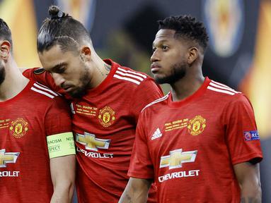 Pemain Manchester United, Bruno Fernandes, Alex Telles dan Fred tertunduk lesu usai ditaklukkan Villarreal pada laga final Liga Europa di Stadion Gdansk, Kamis (27/5/2021). MU gagal menjadi juara usai takluk adu penalti dengan skor 10-11. (AFP/Kackper Pempel/Pool)