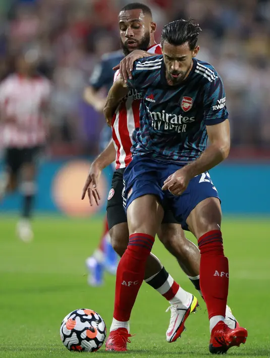 Penyerang Brentford Bryan Mbeumo berebut bola dengan bek Arsenal Pablo Mari pada laga pembuka Liga Inggris 2021/2022 di Brentford Community Stadium, Sabtu (14/8/2021) dini hari WIB. The Gunners tak berdaya dan takluk 0-2 dari Brentford. (AP photo/Ian Walton)
