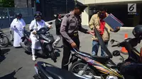 Anggota polisi menggeledah motor tamu pengunjung yang datang ke Mapolda Jawa Tengah, Kota Semarang, Senin (14/5).Tak ingin kecolongan, Mapolda Jateng memperketat pengamanan menyusul aksi teror bom yang bertubi-tubi. (Liputan6.com/Gholib)