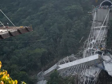 Sebuah jembatan yang menghubungkan Bogota dengan Kota Villavicencio ambruk di kota Guayabetal, Senin (16/1).  Sebanyak 10 pekerja konstruksi tewas dan lima lainnya mengalami cedera ketika jembatan yang sedang dibangun sebagian runtuh. (Raul Arboleda/AFP)