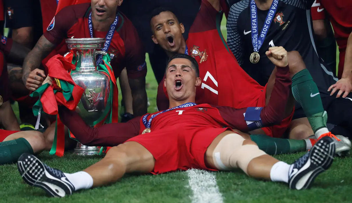Cristiano Ronaldo berbaring dekat tropi Piala Eropa 2016 usai mengalahkan Prancis 1-0 di Stade de France, Senin (11/7). Ronaldo menjadi pemain Portugal yang tampil paling banyak bersama Portugal yaitu sebanyak 133 penampilan. (REUTERS)