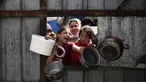 Anak-anak Palestina memberi isyarat saat mereka mengantre untuk mengambil makanan di titik distribusi makanan gratis di kamp pengungsi Nuseirat, Jalur Gaza tengah, pada 3 April 2025. (Eyad BABA/AFP)
