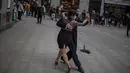 Penari jalanan yang memakai masker menari tango di pusat kota Madrid, Spanyol, Rabu (16/12/2020). Penelitian antibodi yang digelar di seluruh Spanyol menunjukkan satu dari 10 penduduk Spanyol telah terinfeksi oleh virus corona COVID-19 pada paruh kedua bulan November lalu.  (AP Photo/Manu Fernandez)