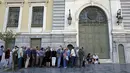Pensiunan mengantri di pintu masuk Bank Nasional untuk mendapatkan uang pensiunan di bank nasional di Athena, Yunani, (9/7/2015). Banyak bank di Yunani tutup dan penarikan uang tunai dari ATM dibatasi hanya 67 dolar sehari. (REUTERS/Jean Paul Pelissier)