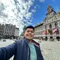 WNI bernama Aris Munandar saat&nbsp;berada di Grote Markt, dengan latar belakang Stad Huis (City Hall). Di depan Stad Huis ada patung Silvius Brabo yang menjadi ikon Kota Antwerp. (Dok. Liputan6.com/Aris Munandar)