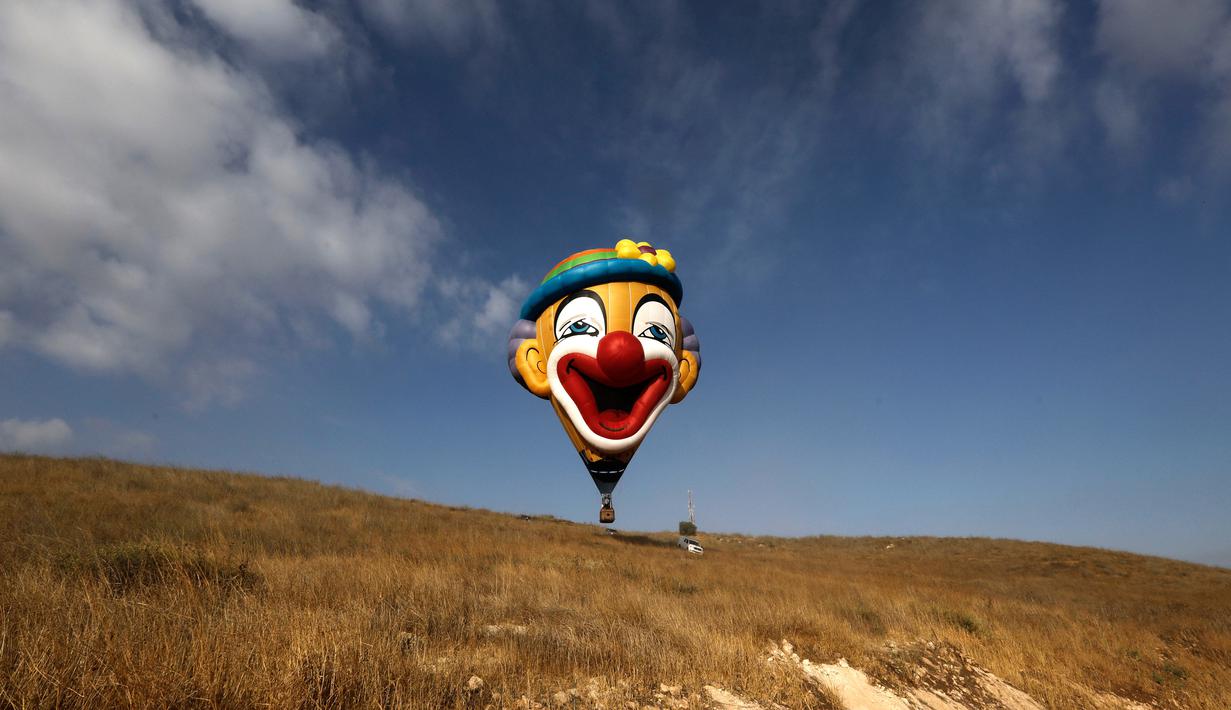 Balon udara berkarakter badut bersiap mengudara saat Festival Balon Udara Gilboa di dekat Kibbutz Ein Harod, Lembah Jizreel, Israel (4/8). (AFP Photo/Manahem Kahana)