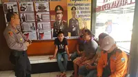 Dengan muka tertunduk, sejumlah warga di kawasan wisata air hangat Cipanas, akhirnya digiring ke mapolsek Tarogong Kaler, setelah menjadi viral akibat dugaan pungli yang mereka lakukan kepada sejumlah pengunjung (Liputan6.com/Jayadi Supriadin)