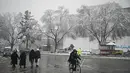 Seorang pria mengendarai sepedanya di sepanjang jalan saat hujan salju lebat di Kabul (4/1/2022). Beberapa kecelakaan terjadi pada Senin (3/1) di tengah kondisi lalu lintas yang kacau setelah hujan salju lebat. (AFP/Mohd Rasfan)