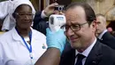 Presiden Prancis Francois Hollande diperiksa suhunya saat mengunjungi rumah sakit Donka, Guinea, 28 November 2014. Francois menjadi pimpinan Barat pertama yang mengunjungi negara yang terkena dampak terparah dari Ebola. (AFP PHOTO/ POOL/ALAIN JOCARD)