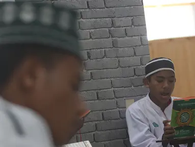 Seorang santri membaca Al-Quran di Pesantren Nuu Waar Al Fatih Kaffah Nusantara (AFKN) di Setu, Kabupaten Bekasi, Jawa Barat, Sabtu (1/5/2021). Kegiatan Khatam Al-Quran tersebut dilakukan rutin setiap bulan Ramadhan oleh 750 santri dan santriwati. (Liputan6.com/Herman Zakharia)