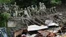 Tim penyelamat melanjutkan operasi pencarian di lokasi tanah longsor di Izusan di Atami, prefektur Shizuoka, barat daya Tokyo, Senin (5/7/2021). Evakuasi korban hilang terus dilakukan menyusul bencana tanah longsor akibat hujan lebat di kota tersebut. (Kyodo News via AP)