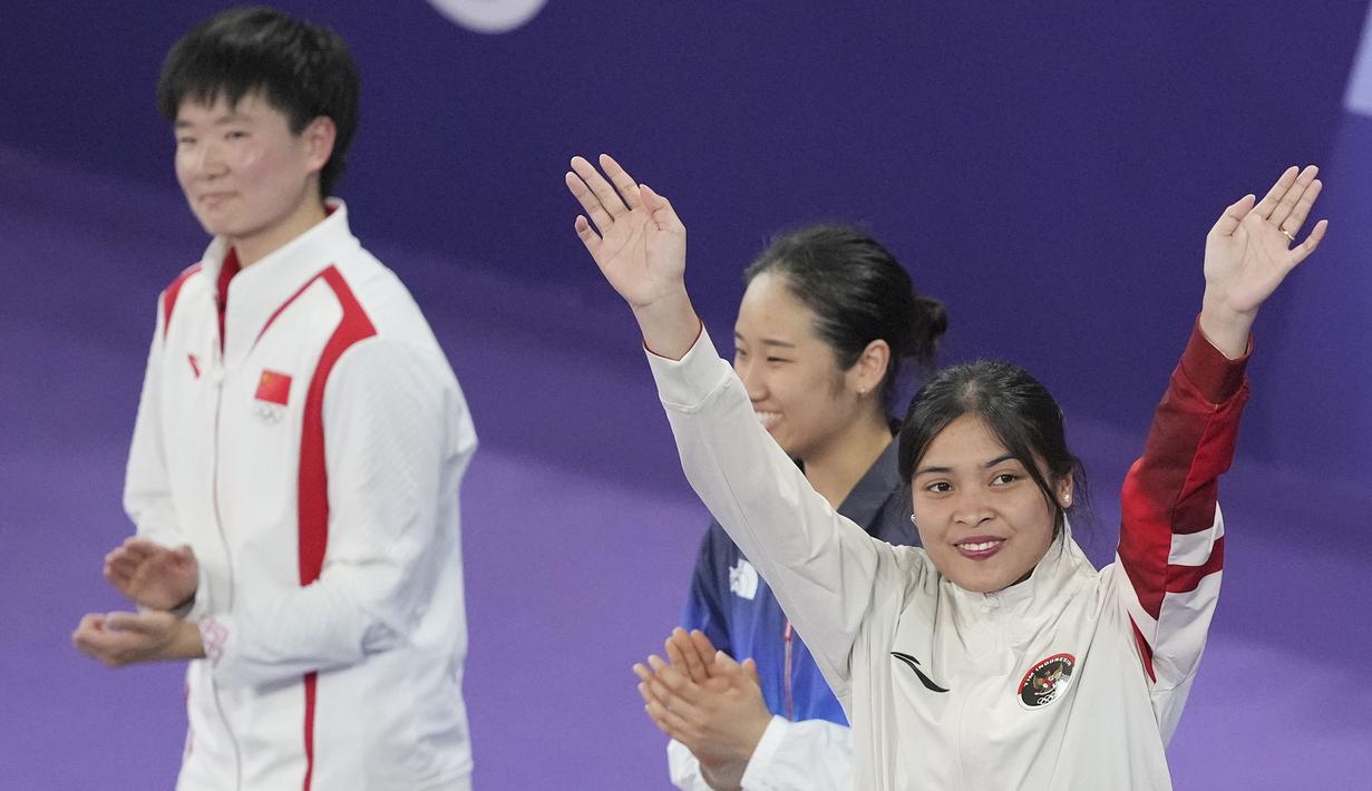Pebulu tangkis Indonesia, Gregoria Mariska Tunjung menaiki podium juara untuk menerima pengalungan medali perunggu nomor tunggal putri cabor bulu tangkis Olimpiade Paris 2024 saat upacara penyerahan medali di Porte de La Chapelle Arena, Paris, Senin (5/8/2024). (AP Photo/Dita Alangkara)