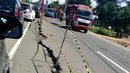 Kendaraan melintasi jalan retak di Kabupaten Pidie Jaya, Aceh, Kamis (8/12). Gempa berkekuatan 6,5 SR pada Rabu pagi menyebabkan sejumlah ruas jalan retak dan mengalami kerusakan. (Liputan6.com/Angga Yuniar)