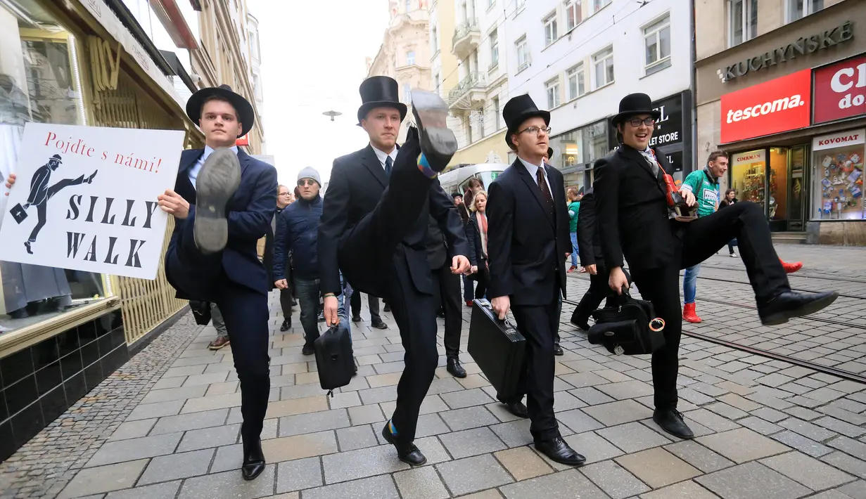 Sejumlah pria mengenakan kostum berjalan dengan mengangkat tinggi kakinya di Brno, Republik Ceko (7/1). Mereka berjalan dengan mengenakan kostum tersebut dalam acara International Silly Walk Day.  (AFP Photo/Radek Mica)