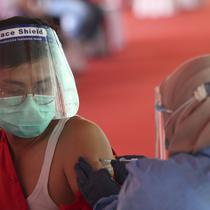 Seorang pria menerima suntikan vaksin Sinovac saat vaksinasi massal virus corona COVID-19 untuk umum di Stadion Patriot Candrabhaga, Bekasi, Jawa Barat, Senin (14/6/2021). Peminat vaksinasi COVID-19 di Stadion Patriot Candrabagha sangat tinggi. (AP Photo/Achmad Ibrahim)