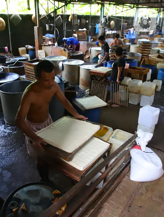 Perajin menata tahu di Jakarta, Senin (4/1/2021). Setelah melakukan mogok produksi selama 1 hingga 3 Januari 2021 akibat naiknya harga kacang kedelei impor, kini para perajin tahu mulai kembali beroperasi. (Liputan6.com/Angga Yuniar)