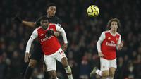 Pemain Arsenal, Ainsley Maitland-Niles, berebut bola dengan pemain Manchester United, Anthony Martial, pada laga Premier League di Stadion Emirates, Rabu (1/1/2020). Arsenal menang 2-0 atas Manchester United. (AP/Matt Dunham)