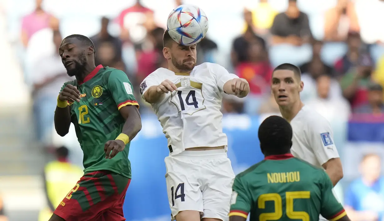 Gelandang Serbia Andrija Zivkovic menyundul bola melewati penyerang Kamerun Karl Toko Ekambi  pada matchday 2 Grup G Piala Dunia 2022 di Al Janoub Stadium, Senin (28/11/2022). Serbia tidak melakukan banyak perubahan susunan pemain saat menghadapi Kamerun di laga kedua Piala Dunia Qatar.  (AP Photo/Francisco Seco)