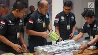 Petugas menata barang bukti saat rilis kasus narkotika jaringan internasional di Polda Metro Jaya, Kamis (13/6/2019). Ditnarkoba bekerja sama dengan Ditjen Bea Cukai mengungkap tiga kasus penyelundupan narkotika jaringan internasional dengan barbuk 45 kg sabu. (Liputan6.com/Immanuel Antonius)