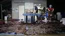 Foto yang diambil 1 Juni 2018 memperlihatkan tim dokter mengeluarkan kantong plastik dari perut paus pilot di Provinsi Songkla, Thailand. Otopsi mengungkap 80 kantong plastik yang berada di perut paus itu beratnya mencapai 8 kilogram. (AFP/ThaiWales)