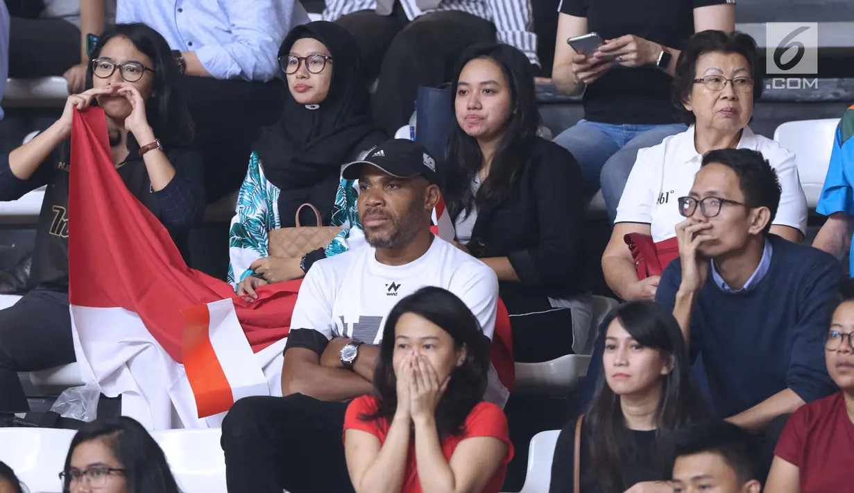 Suporter Indonesia terlihat tegang saat menyaksikan laga basket putri Indonesia melawan Korea pada babak penyisihan Grup X Basket Putri Asian Games 2018 di Jakarta, Rabu (15/8). Indonesia kalah 40-108. (Liputan6.com/Helmi Fithriansyah)