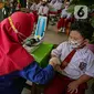 Petugas mengecek kesehatan murid sekolah dasar sebelum menerima vaksinasi COVID-19 di SDN 04 Pagi Cilandak Barat, Jakarta, Selasa (14/12/2021). Pemerintah lewat Kementerian Kesehatan mulai memberikan vaksinasi COVID-19 untuk anak usia 6-11 tahun. (Liputan6.com/Faizal Fanani)