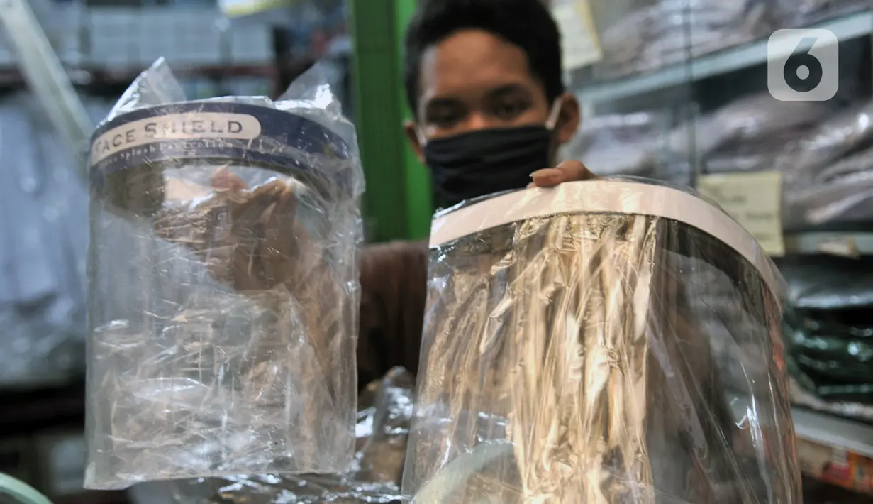 Pedagang menunjukkan alat pelindung wajah atau face shield di salah satu kios Pasar Pramuka, Jakarta, Rabu (3/6/2020). Pemerintah mewajibkan petugas pelayanan, pedagang, serta pekerja toko swalayan dan mal mengenakan face shield saat fase new normal diterapkan. (merdeka.com/Iqbal S. Nugroho)