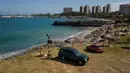 Pasangan Juan Peñalver dan Victoria Colina beristirahat di pantai Mansa setelah dibuka kembali di La Guaira, Venezuela, Jumat (23/10/2020). Pemberlakuan lockdown yang ketat akibat COVID-19 memaksa penutupan pantai di seluruh negeri pada Maret lalu dan dibuka kembali minggu ini. (AP/Matias Delacroix)