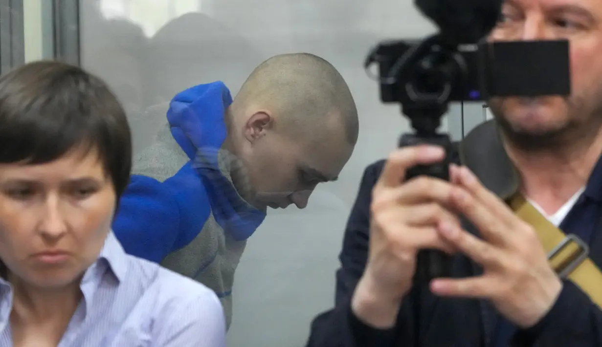 <p>Tentara Rusia, Sersan Vadim Shishimarin (21) terlihat di balik kaca selama sidang pengadilan di Kiev, Ukraina, Rabu (18/5/2022). Sersan Vadim Shishimarin dapat terancam hukuman seumur hidup karena membunuh warga sipil Ukraina berusia 62 tahun di desa Chupakhivka, Ukraina timur laut pada 28 Februari. (AP Photo/Efrem Lukatsky)</p>