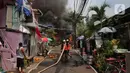 Petugas pemadam kebakaran berusaha memadamkan api saat terjadi kebakaran di kawasan padat penduduk di Jalan Simprug Golf II RT 4/8, Grogol Selatan, Kebayoran Lama, Jakarta Selatan, Minggu (21/8/2022). Belum diketahui penyebab kebakaran yang membakar puluhan rumah tersebut. (Liputan6.com/Angga Yuniar)