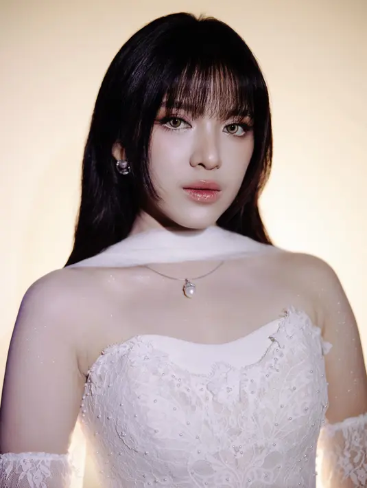 Rambutnya dibiarkan tergerai dengan sedikit gelombang natural dan poni lurus di depan. Makeup-nya tampil soft glam dengan eyeshadow bernuansa cokelat keemasan, eyeliner tipis membentuk sudut mata, serta bibir glossy nude yang memberi kesan romantis dan elegan [@tiaraandini]