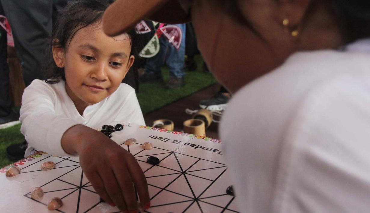 Anak-anak mencoba permainan tradisional di acara Teras Main Indonesia 2025 di Taman Mini Indonesia Indah (TMII), Jakarta, Sabtu (15/11/2025). Sebagai upaya pelestarian budaya, Komite Permainan Rakyat dan Olahraga Tradisional Indonesia (KPOTI) menggelar festival permainan tradisional bertajuk Teras Main Indonesia 2025. (merdeka.com/Arie Basuki)