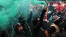 Peserta aksi dari berbagai serikat buruh menyalakan suar atau flare dalam peringatan Hari Buruh 2019 di Jalan Jenderal Sudirman dekat Bundaran HI, Jakarta, Rabu (1/5/2019). Massa sempat terlibat aksi saling dorong dengan barisan polisi agar bisa masuk menuju Bundaran HI. (Liputan6.com/Johan Tallo)