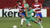Gelandang Real Madrid, Isco, berebut bola dengan gelandang Granada, Fede Vico, pada laga lanjutan La Liga pekan ke-36 di di Estadio Nuevo Los Carmenes, Selasa (14/7/2020) dini hari WIB. Real Madrid menang 2-1 atas Granada. (AFP/Jorge Guerrero)