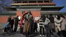 <p>Seorang perempuan berswafoto dengan haw China berlapis gula saat pengunjung berkumpul di luar Menara Drum di Beijing, Senin (30/1/2023). Orang-orang China menikmati Tahun Baru Imlek dan mengunjungi berbagai lokasi wisata di kota-kota di sekitar China setelah pencabutan pembatasan COVID-19 yang kejam bulan lalu, memungkinkan banyak aspek kehidupan normal kembali. (AP Photo/Andy Wong)</p>