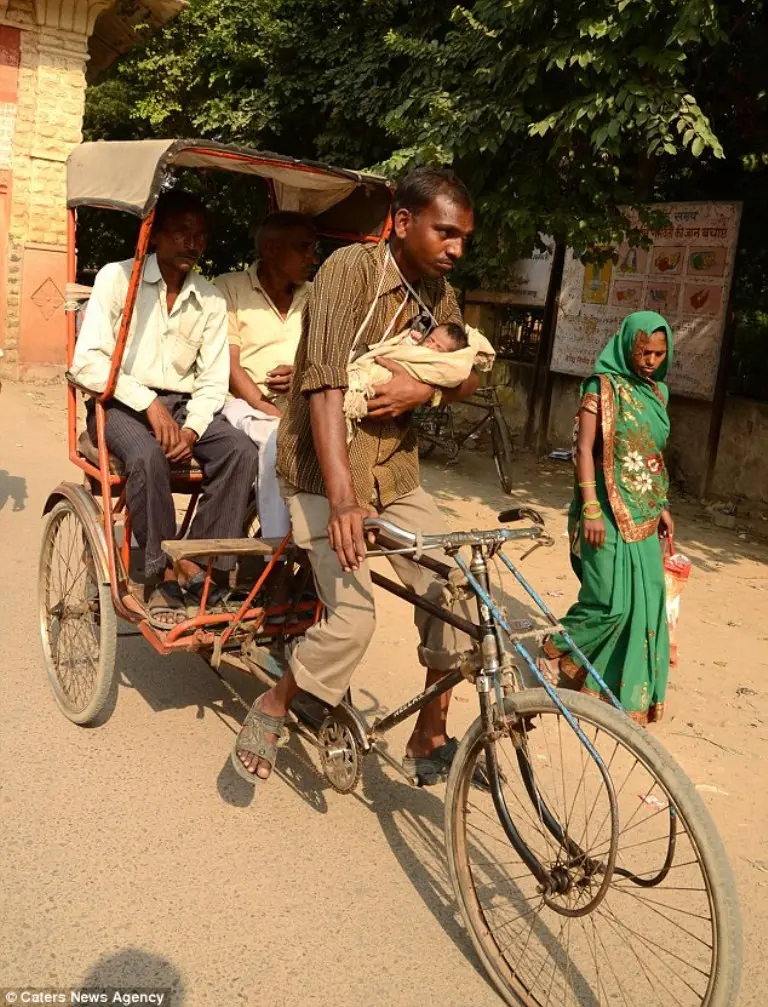Jatav mengayuh rickshawnya sambil menggendong sang buah hati yang masih berusia 1 bulan. | Sumber Foto: Caters News Agency/Dailymail