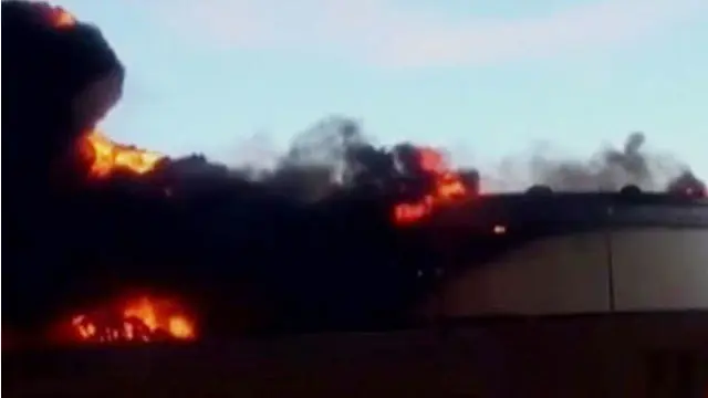 Kobaran api disertai kepulan asap hitam membubung di atas kota Ras Lanuf.
