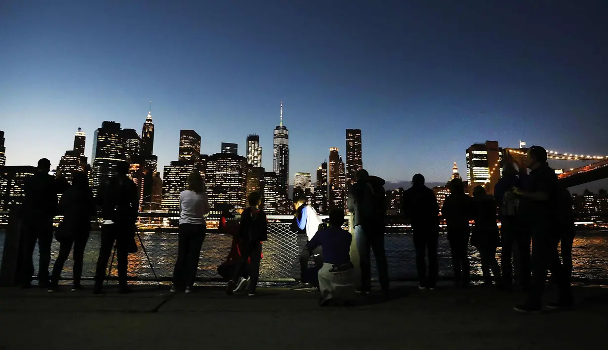Sejumlah warga menikmati taman Brooklyn setelah matahari terbenam pada hari di mana suhu mencapai mendekati 70 derajat di New York City (21/2). (AFP Photo/Spencer Platt)
