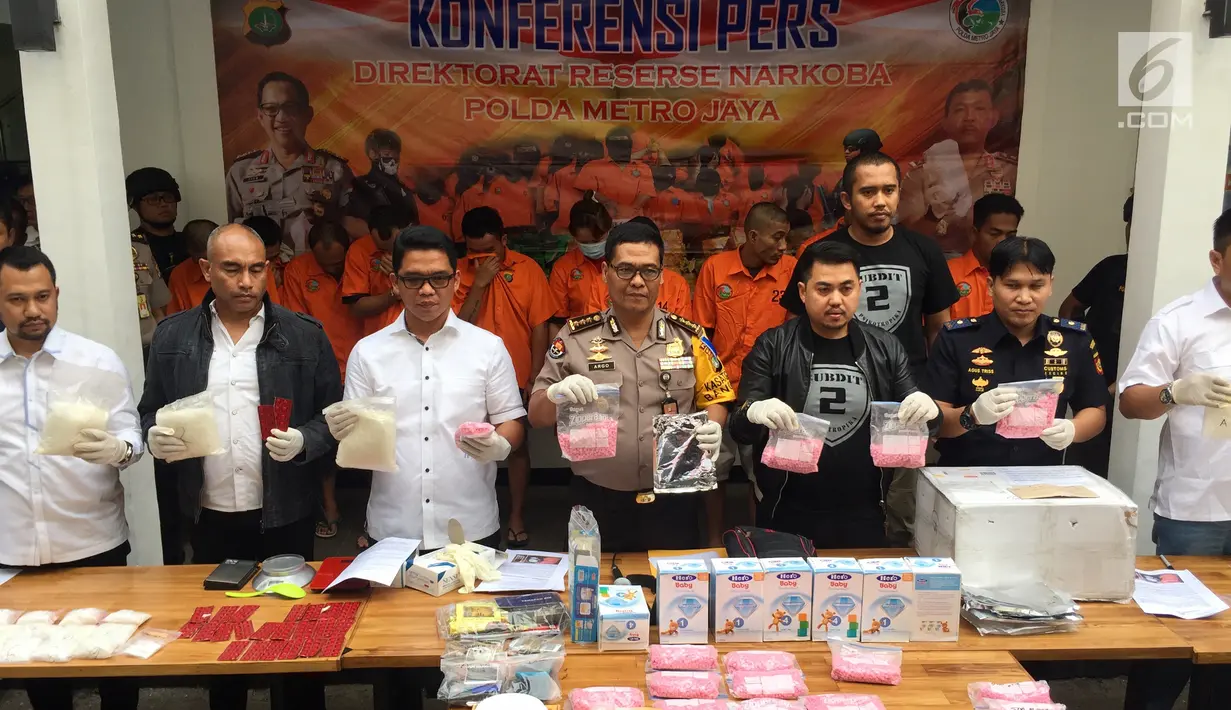 Petugas menunjukkan barang bukti beserta tersangka kasus tindak pidana narkotika jenis ekstasi dan shabu di Polda Metro Jaya, Jakarta, Rabu (27/12). (Liputan6.com/Immanuel Antonius)