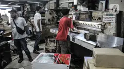 Pekerja saat menyelesaikan pembuatan kalender 2022 di toko percetakan kawasan Senen, Jakarta, Senin (27/12/2021). Jelang tahun baru 2022 permintaan kalender meningkat hingga 20 persen dibandingkan tahun sebelumnya. (merdeka.com/Iqbal S Nugroho)