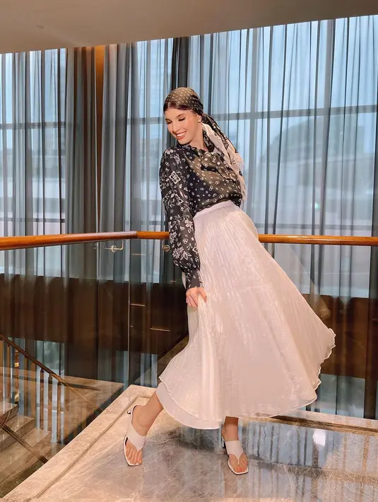 Tampil feminin, Mikaila Patritz padukan pleated skirt putih dengan kemeja satin bermotif [@mikailapatritz]