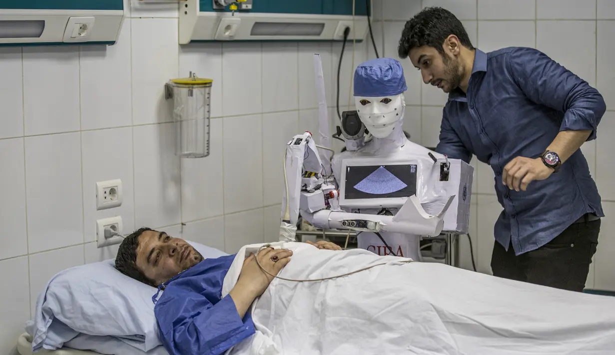 Mahmoud El Komy, seorang insinyur mekatronika, menguji prototipe robot CIRA-03 kendali jarak jauh yang didanai sendiri untuk membantu dokter dalam menjalankan tes pada pasien yang dicurigai COVID-19 di rumah sakit swasta di kota Tanta, Mesir pada 20 Maret 2021. (Khaled DESOUKI/AFP)