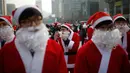 Seorang pria berpakaian seperti Santa Claus merapihkan jengotnya saat acara amal Natal di pusat kota Seoul, Korea Selatan, (24/12/2015). (REUTERS/Kim Hong-Ji)