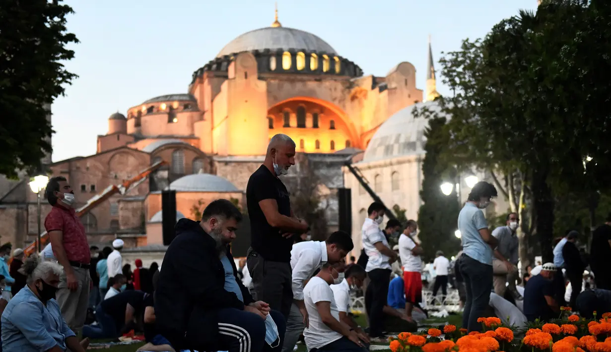 Umat muslim melaksanakan salat di luar Hagia Sophia, Istanbul, Turki, Kamis (23/7/2020). Alih fungsi bangunan gereja era Bizantium tersebut menjadi masjid telah memicu protes internasional. (AP Photo/Omer Kuscu)