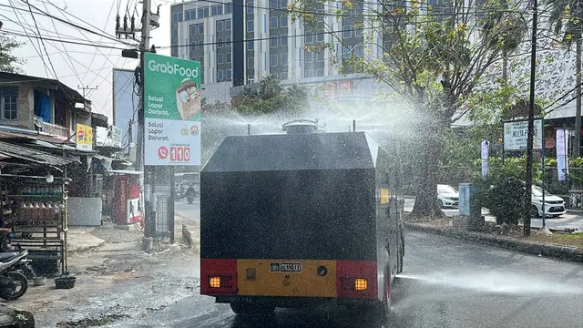 Kendaraan taktis milik Brimob Polda Lampung melakukan penyemprotan air ke jalan protokol untuk meminimalisir debu vulkanik. (Liputan6.com/Istimewa).
