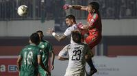 Kiper PSS Sleman, Ega Rizky, meninju bola dari jangkauan bek Arema FC, Arthur Cunha, pada laga Liga 1 2019 di Stadion Maguwoharjo, Sleman, Rabu (15/5). PSS menang 3-1 atas Arema. (Bola.com/Yoppy Renato)