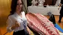 Miss Prancis, Maeva Balan-Merceron berfoto bersama daging ikan tuna sirip biru yang akan di buat menjadi Sushi di Tokyo, Jepang (12/11). Malam final Miss Internasional akan digelar pada 14 November 2017 di Tokyo. (AFP Photo/Toshifumi Kitamura)