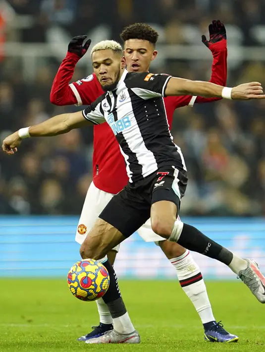 Pemain Newcastle United Joelinton (depan) berduel memperebutkan bola dengan pemain Manchester United Jadon Sancho pada pertandingan sepak bola Liga Inggris di St. James' Park, Newcastle, Inggris, Senin (27/12/2021). Pertandingan berakhir imbang 1-1. (AP Photo/Jon Super)