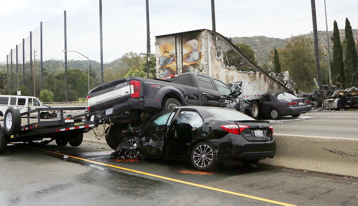 Sejumlah mobil rusak berat akibat tabrakan antara dua truk besar di utara pusat kota Los Angeles (25/4). Kecelakaan ini menimbulkan kerusakan yang cukup parah pada kendaran yang berada dekat dengan truk yang bertabrakan. (AP Photo/Reed Saxon)